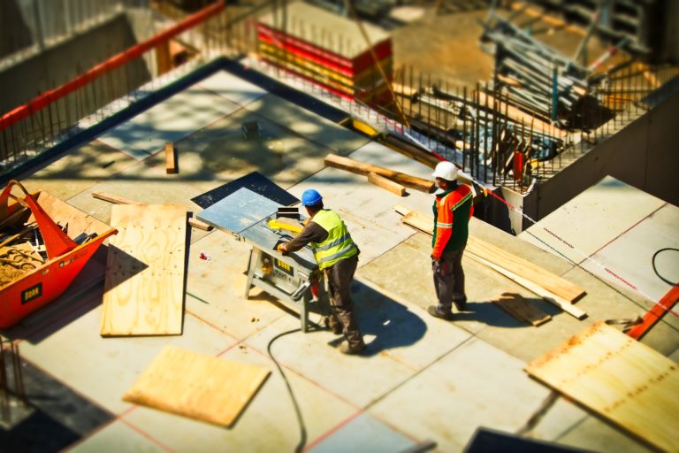 Ons team Bouwvakkers op een baan als timmerman werken op een constructieplaats met bouwmateriaal en gereedschap